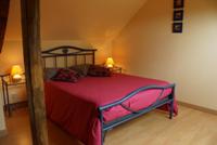 La chambre beige avec un lit double